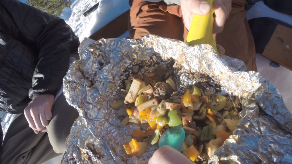 Digging into a campfire foil packs meal