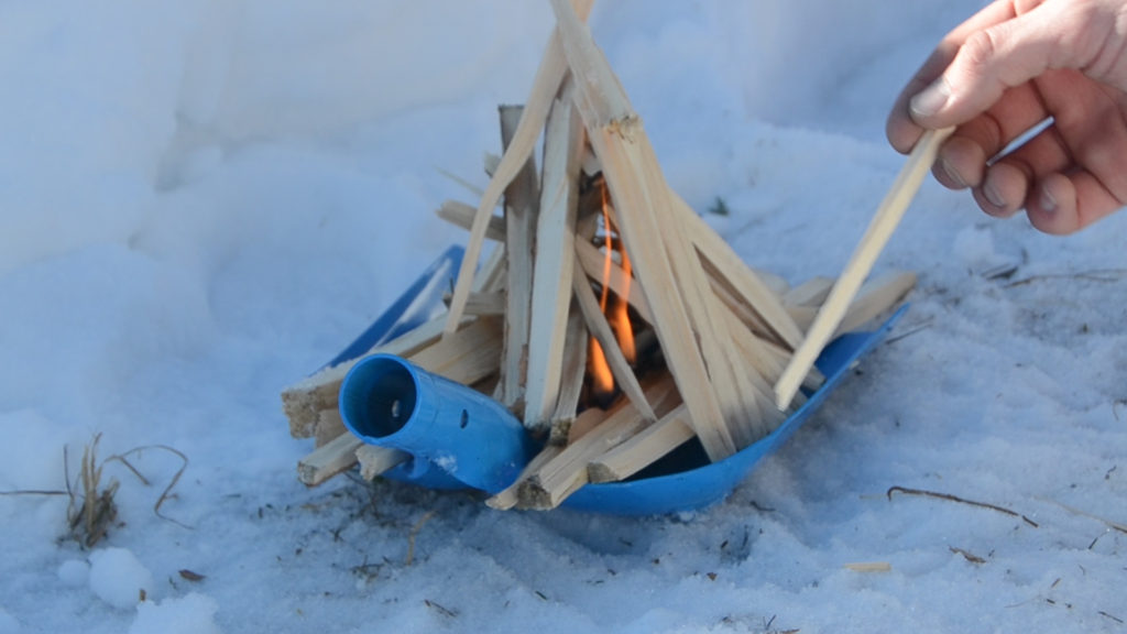 Use a snow shovel to start a fire in the snow